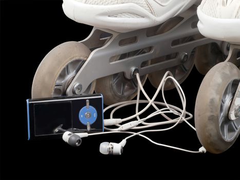 roller skates and mp3 player with headphones isolated on black background