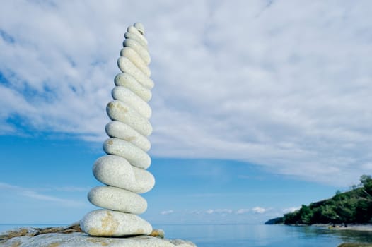 Balancing white pebbles each other on the seacoast