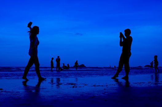 siluet people walking on the beach blue background