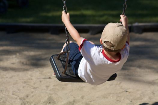 Little boy alone on a swing
