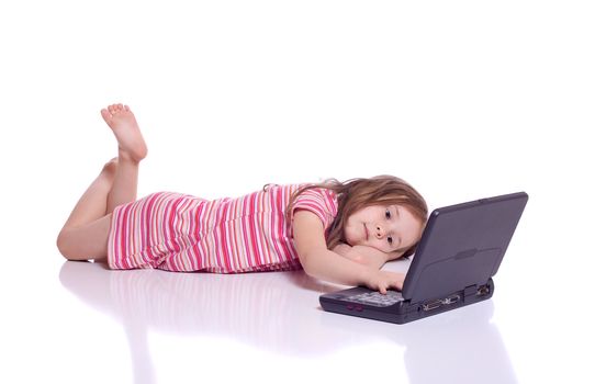 Cute little girl laying on her stomach with a laptop