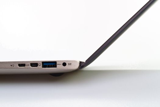 closeup view of the various ports and power cable on the side of a moderm laptop