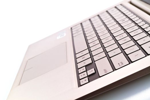 Angled view of a keyboardpad on a modern laptop against white for abstract and background