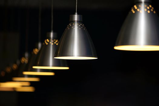 Many metal lamps at dark restaurant