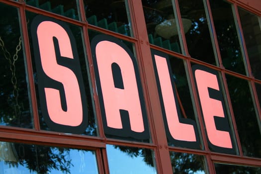 Close up of a sale sign on top of a store.
