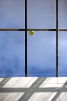 Yellow balloon and window on a background of the sky