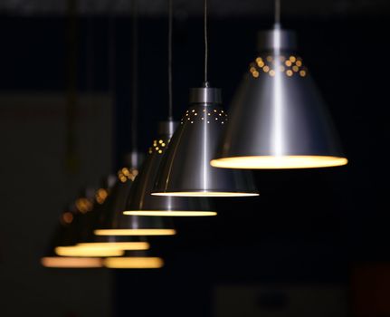 Many metal lamps at dark restaurant
