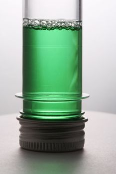 Test tube with a green liquid on a white background