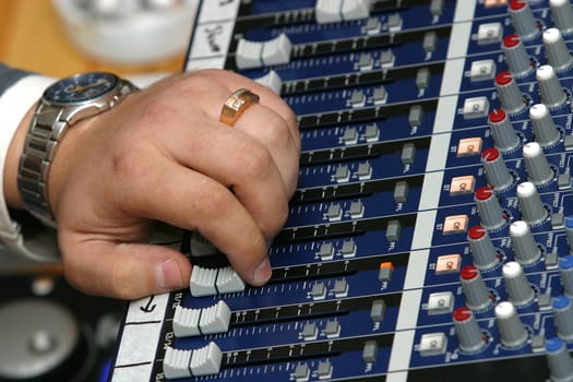 The image of a man's hand managing the musical board