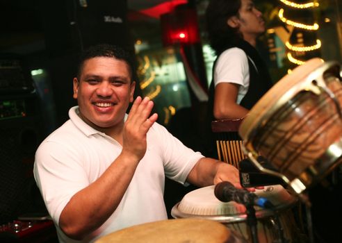 Smiling musician at an alive concert in a night club "La vida loka". Bali. Indonesia