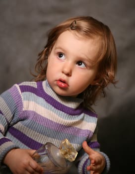 Portrait of the two-year-old girl with a bottle in hands