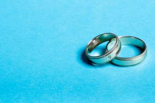 Pair of wedding bands isolated on blue background, macro