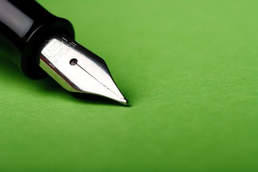 Macro isolated fountain pen on green background