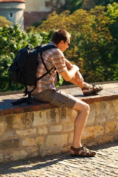 man sitting on a background of green foliage in Prague