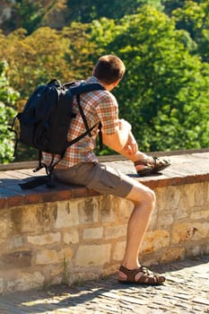 man sitting on a background of green foliage in Prague