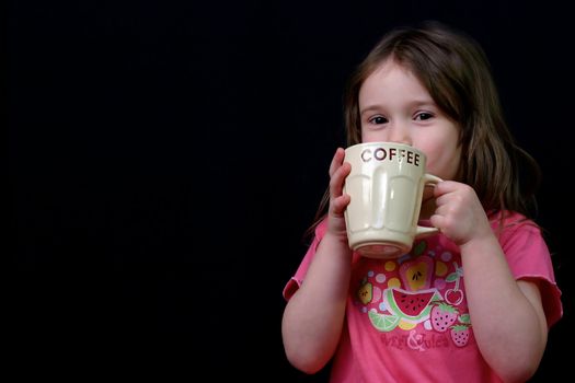 Little girl holding a cup of coffee