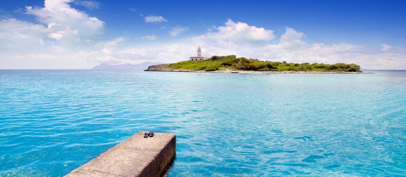 Aucanada Alcanada beach with pier view to island and lighthouse in Mallorca Balearics