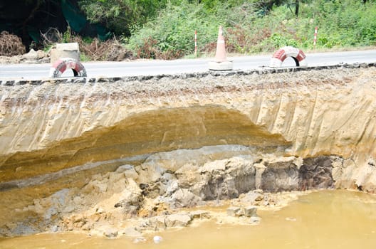 Asphalt road has been damaged by flooding.