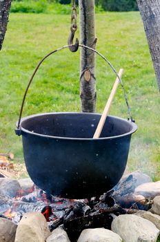 Old pot with a spoon over a fire
