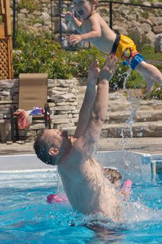 Father and son playing in the pool
