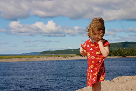 Girl on the beach with a lollipop