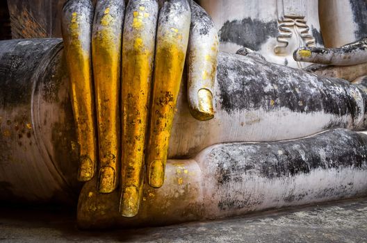 Detail of beautiful golden hand of sitting Buddha in Wat Si Chum temple, Sukhothai, Thailand