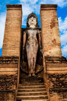 Large statue of standing Buddha in Sukhothai historical park, Thailand