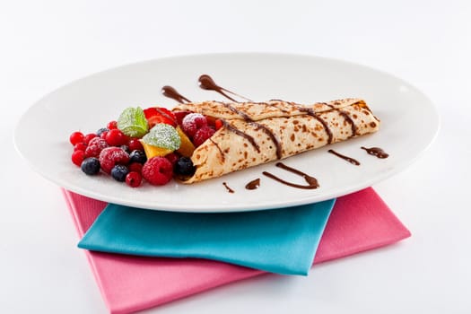 fresh tasty homemade crepe pancake with chocolate sauce fruits and berries