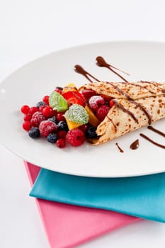 fresh tasty homemade crepe pancake with chocolate sauce fruits and berries