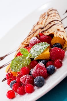 fresh tasty homemade crepe pancake with chocolate sauce fruits and berries