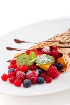 fresh tasty homemade crepe pancake with chocolate sauce fruits and berries