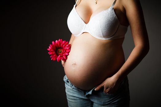 Pregnant woman torso with a flower