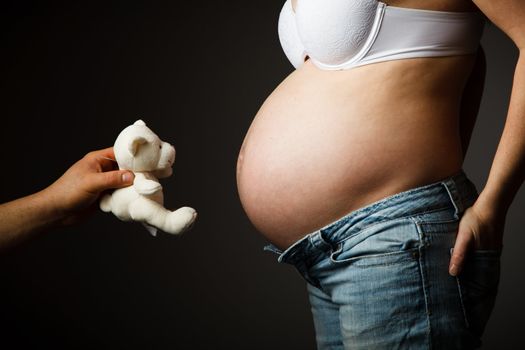 Pregnant woman torso with a teddy