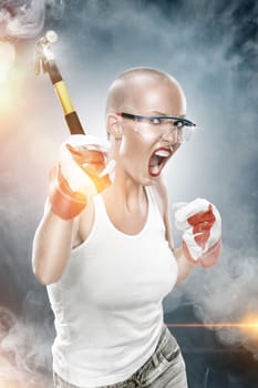 portrait of young beautiful  woman with hammer  on blue back