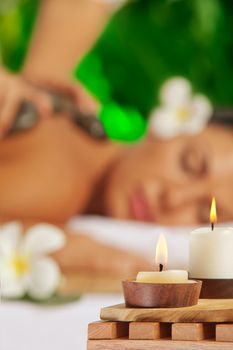 portrait of young beautiful woman in spa environment. Focused on candles.