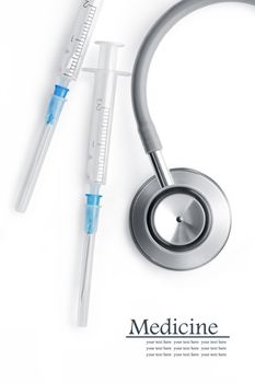 Close up view of  white plastic syringe, stethoscope  on  white back