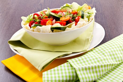 fresh mixed colorful salad on wooden table with green and yellow decoration