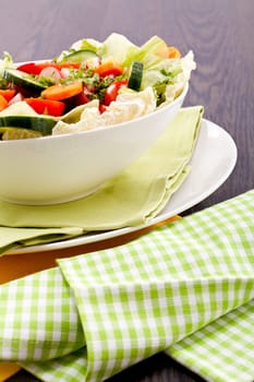 fresh mixed colorful salad on wooden table with green and yellow decoration