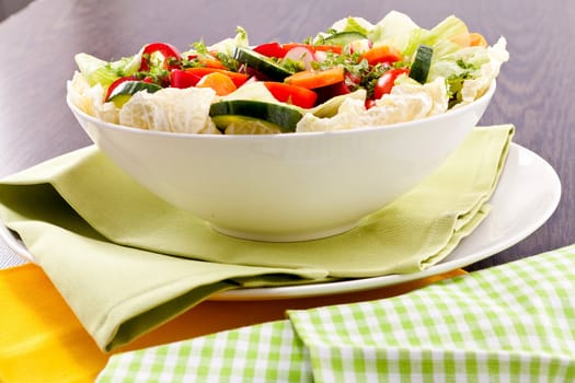 fresh mixed colorful salad on wooden table with green and yellow decoration