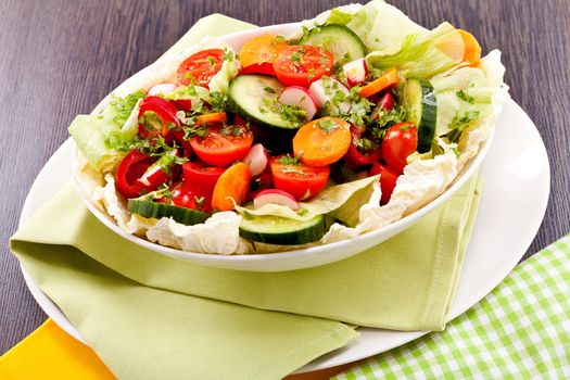 fresh mixed colorful salad on wooden table with green and yellow decoration