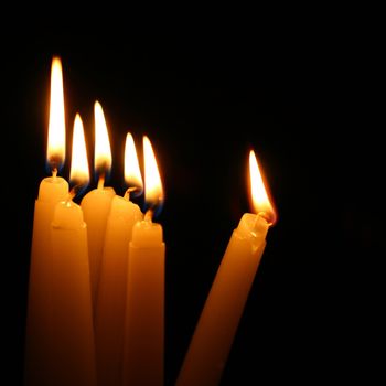 sacred candles in dark on black background