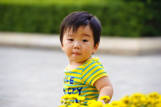 a cute baby is playing in garden