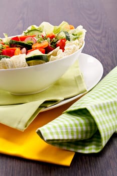 fresh mixed colorful salad on wooden table with green and yellow decoration