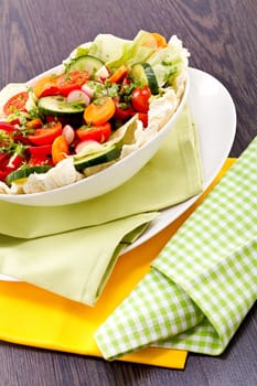 fresh mixed colorful salad on wooden table with green and yellow decoration