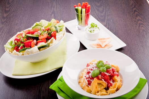 collection of different plates with healthy food pasta salad vegetables on wooden table