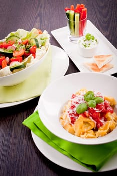 collection of different plates with healthy food pasta salad vegetables on wooden table