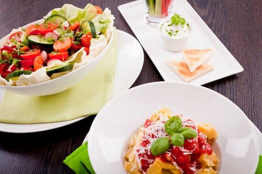 collection of different plates with healthy food pasta salad vegetables on wooden table