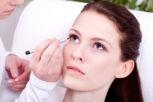 at the cosmetic studio eyeliner on eyes doing make up woman portrait closeup