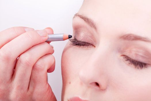at the cosmetic studio eyeliner on eyes doing make up woman portrait closeup
