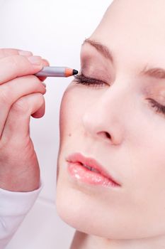 at the cosmetic studio eyeliner on eyes doing make up woman portrait closeup